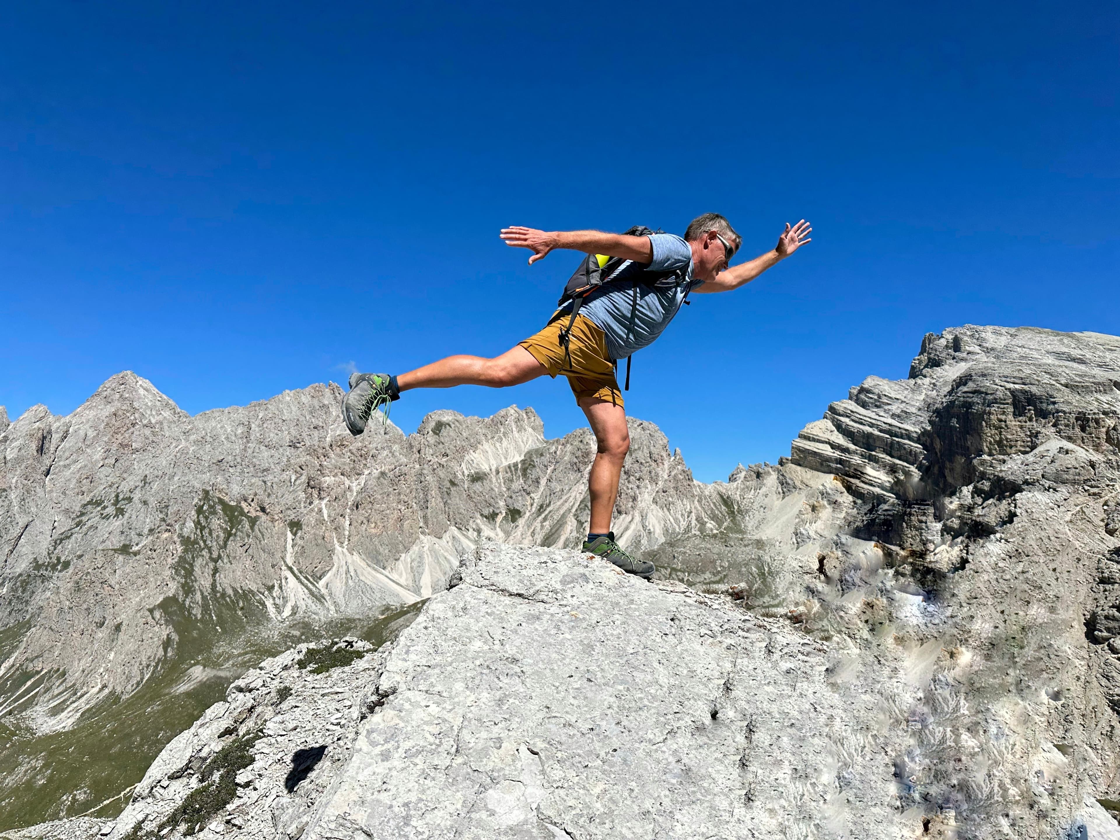 Wanderer auf Felsen vor Dolomitenpanorama